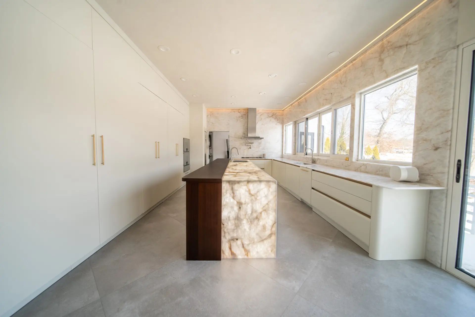 Full-height custom kitchen cabinet wall with sleek white panels and elegant hardware