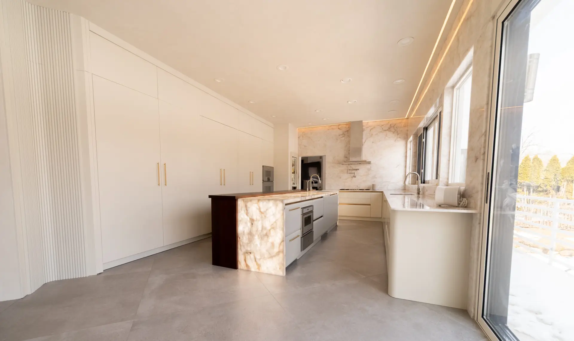 Modern luxury kitchen by Americana Studio with custom cabinetry, full-height cabinets, and Crystalo quartzite details