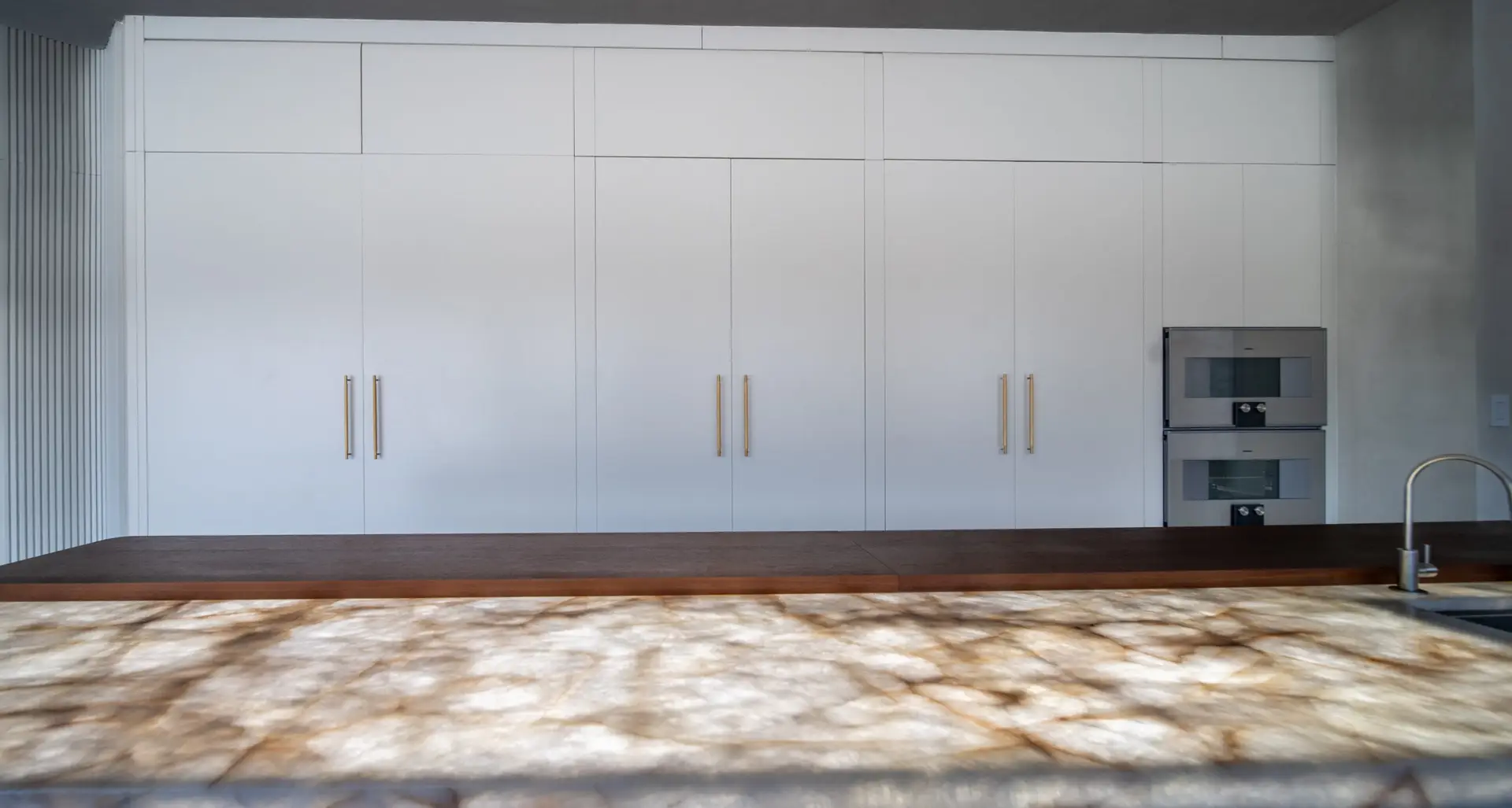 Modern range wall with real quartzite backsplash and minimalist cabinetry in a custom kitchen